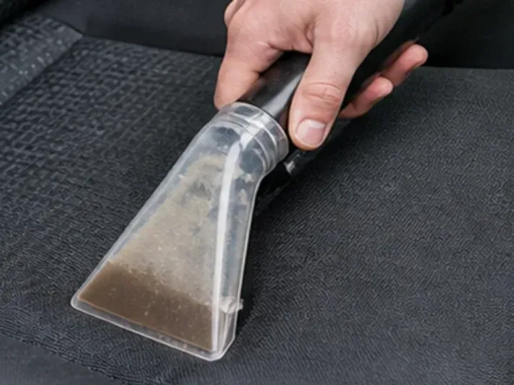 Extracción de agua sucia de la tapicería de un asiento de coche
